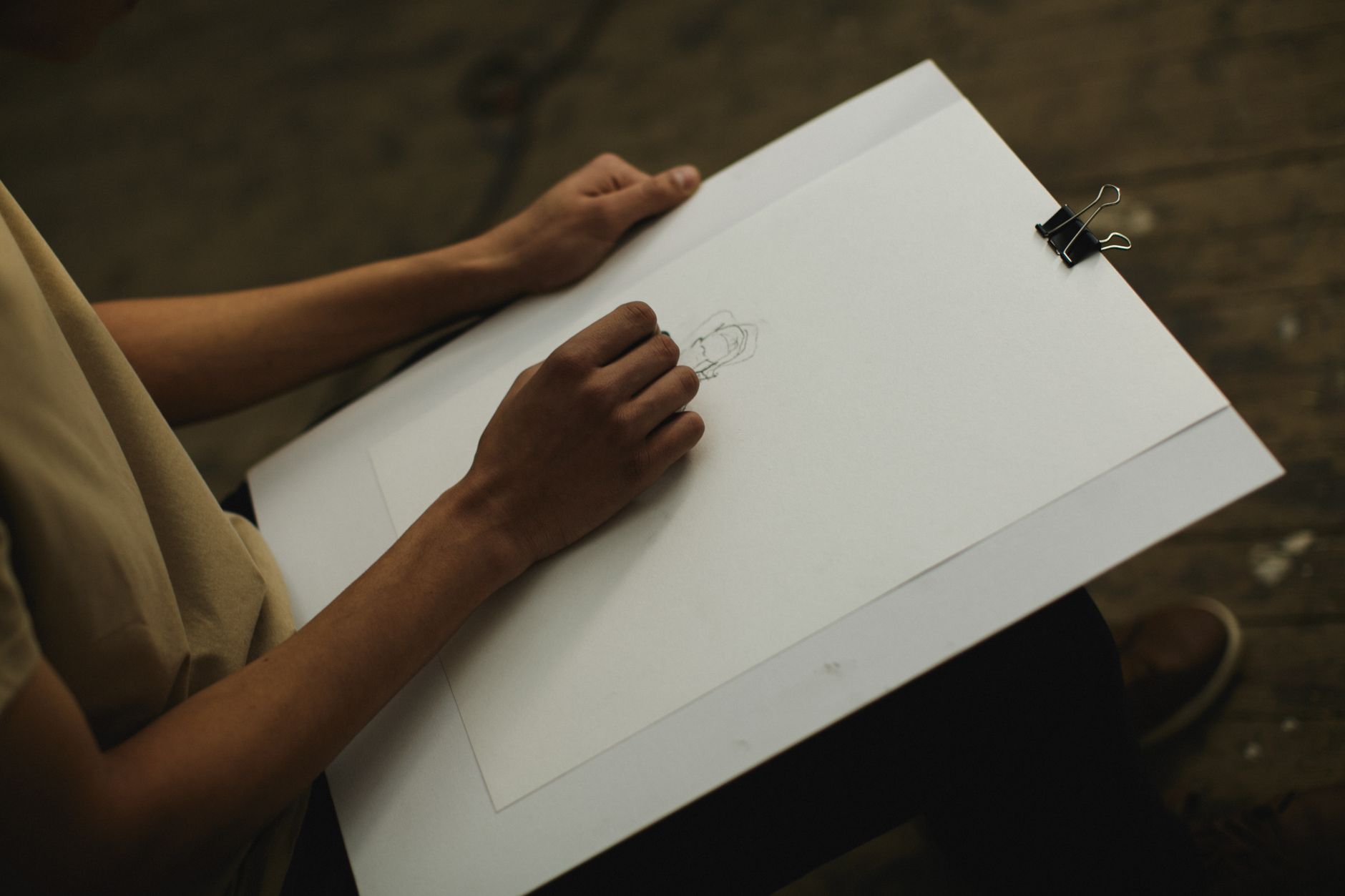 Person drawing on a large sheet of paper